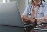 Nurse writing on a laptop